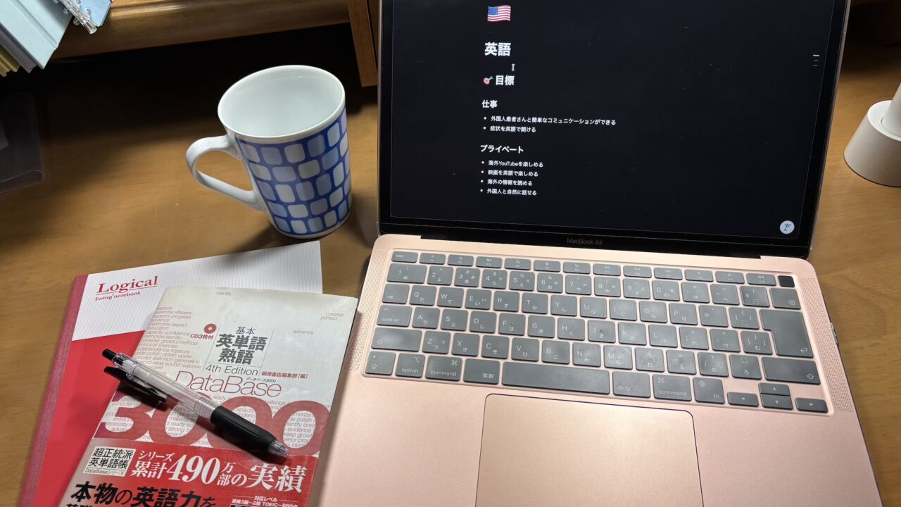 MacBookと本とノートとペンとマグカップ
