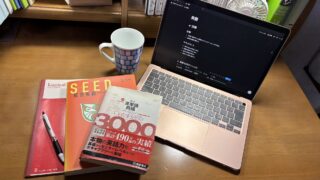 MacBookと本とノートとペンとマグカップ